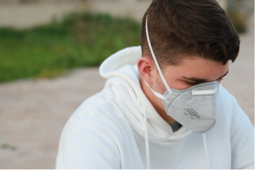 This image shows a college student wearing a face mask